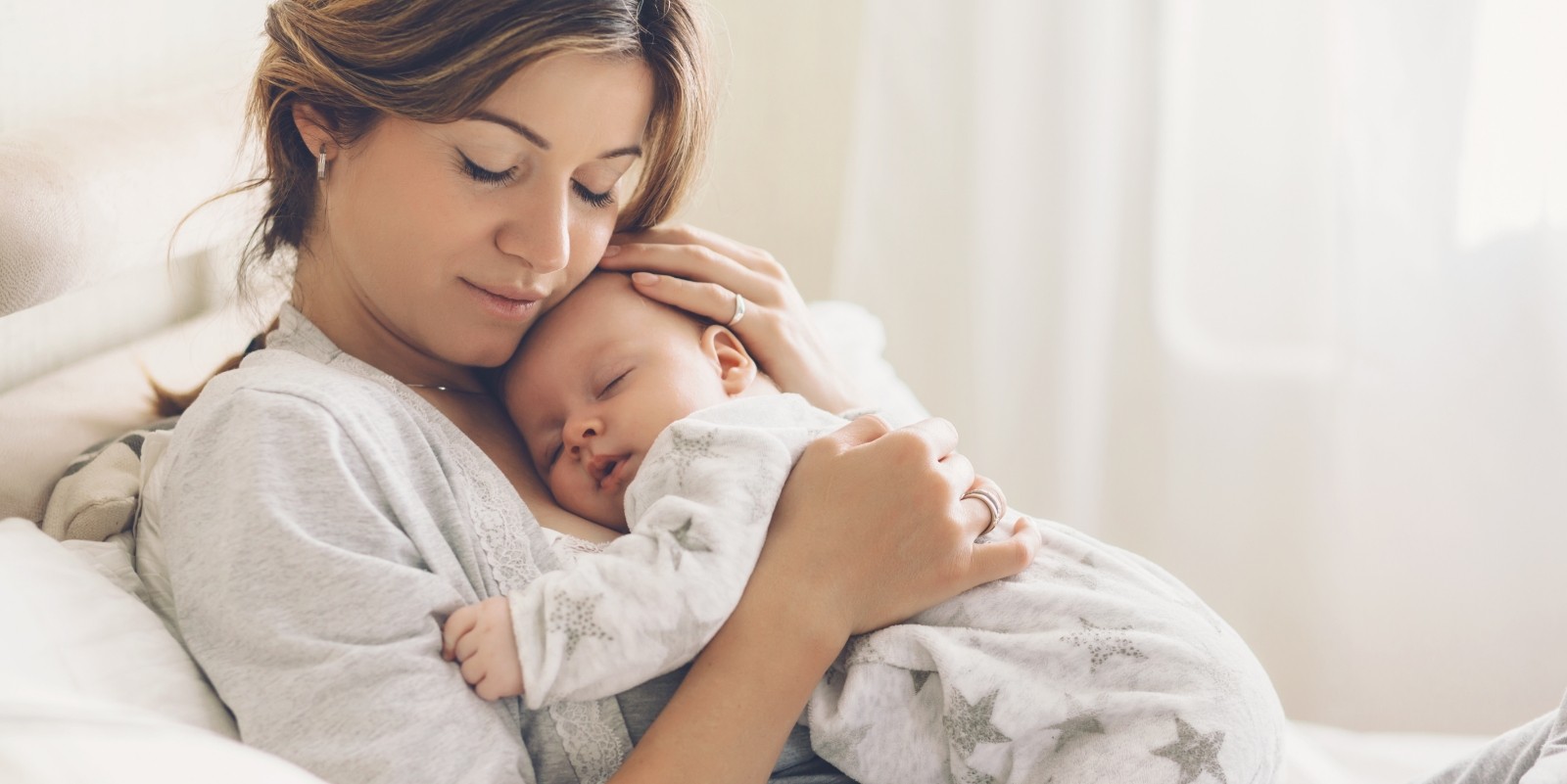 Mother holding her baby after visiting lip and tongue tie dental office in Hamilton