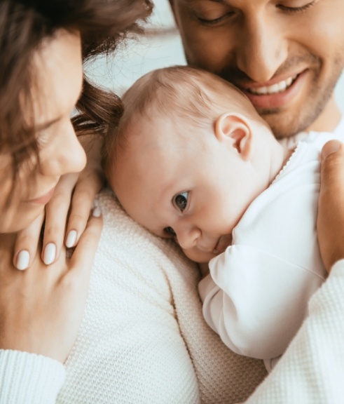 Mother and father smiling at their baby