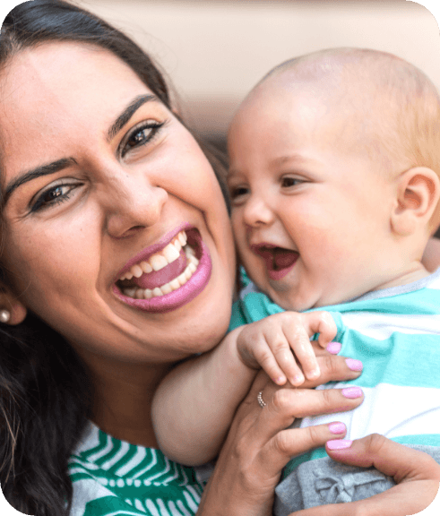 Woman smiling while holding her laughing baby