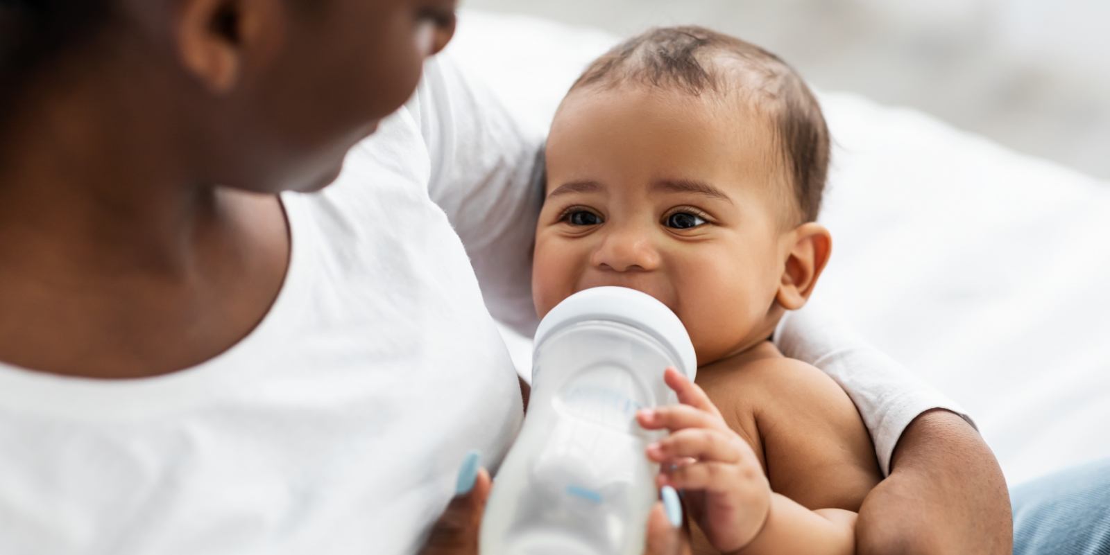 Baby feeding from a bottle after lip tie treatment in Hamilton