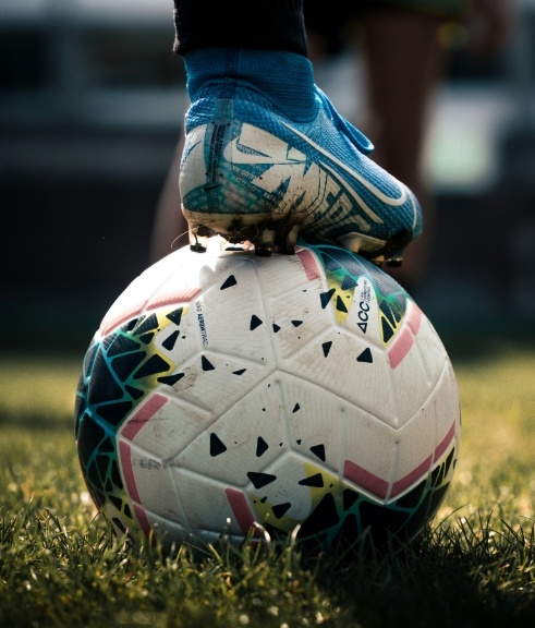 Foot with soccer cleet on top of a soccer ball