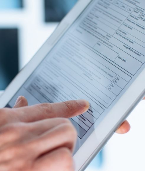 Person filling out a form on a tablet