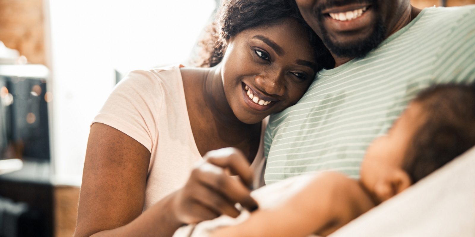 Mother and father smiling at their baby